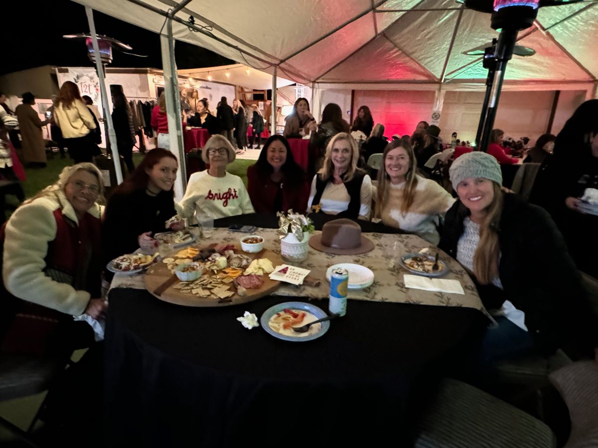 Seven guests around a table with a large cheese and charcuterie board