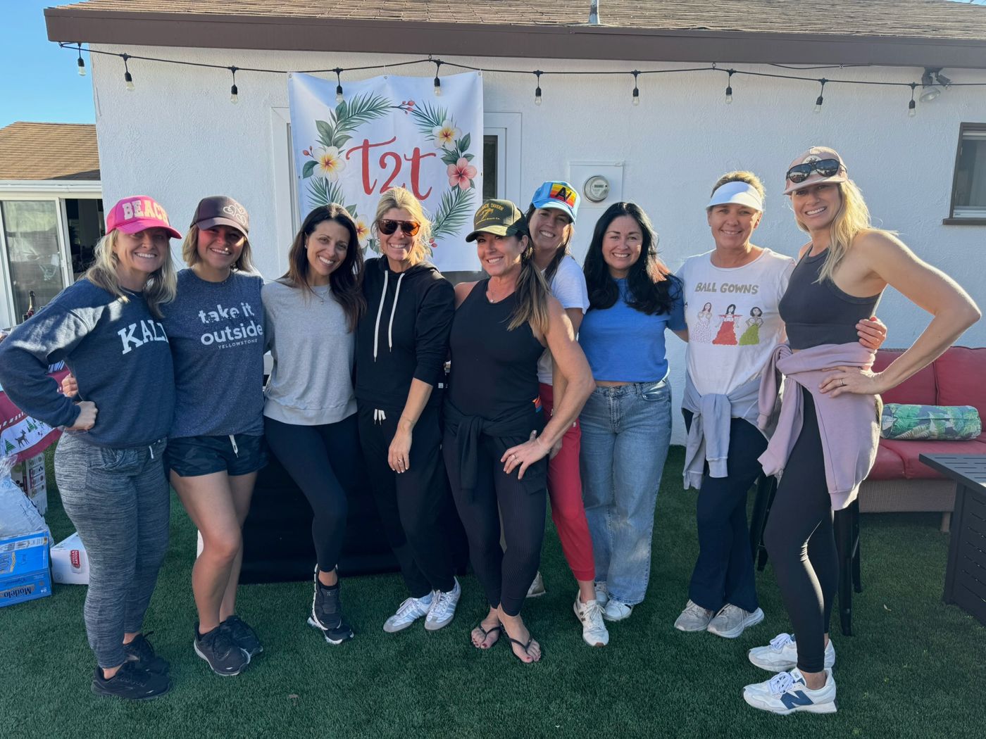 Nine women in front of the T2T banner in the backyard