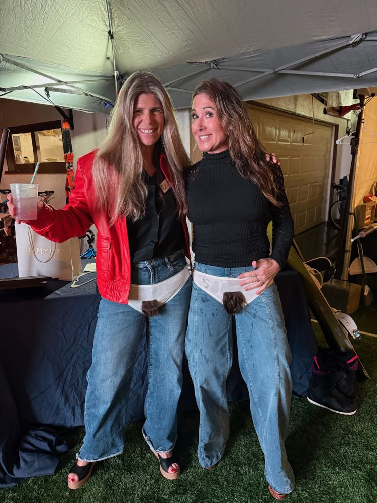 Two friends laughing and showing off their finds under the tent