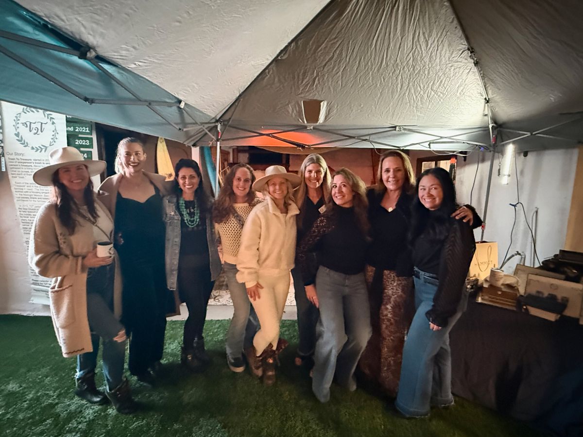 A group of friends arm in arm under the party tent